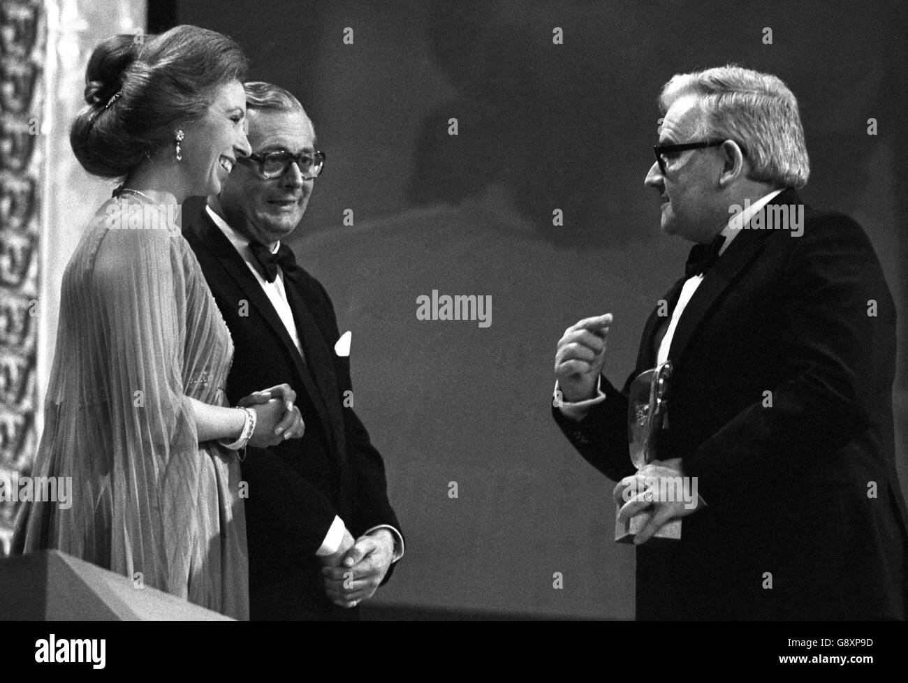 Prinzessin Anne, Präsidentin der British Academy of Film and Television Arts, wird von den Bemerkungen des Komikers Ronnie Barker gekitzelt, nachdem sie ihm während der Preisverleihung der Academy 1977 im Wembley Conference Center den Preis für die beste Light Entertainment Performance überreicht hatte. Stockfoto