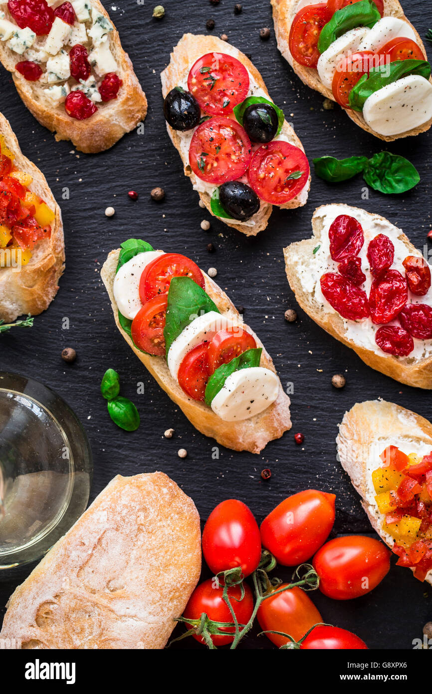 Italienische Bruschetta mit Cherry-Tomaten, Kräuter, Oliven, Mozzarella auf geröstetes knuspriges Ciabatta-Brot Stockfoto