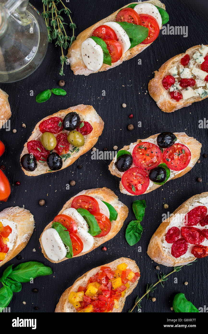 Italienische Bruschetta mit Cherry-Tomaten, Kräuter, Oliven, Mozzarella auf geröstetes knuspriges Ciabatta-Brot Stockfoto