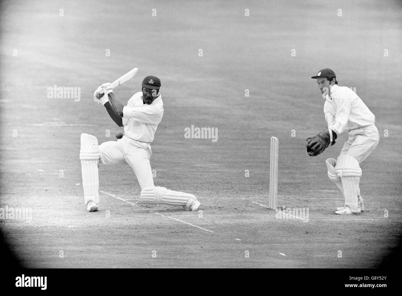 Cricket - England XI gegen Rest der Welt XI - 3. Tag - Lords, London. West Indian Clive Lloyd (Rest der Welt) in Batting Action. England Wicketkeeper Alan Knott (r) schaut zu Stockfoto