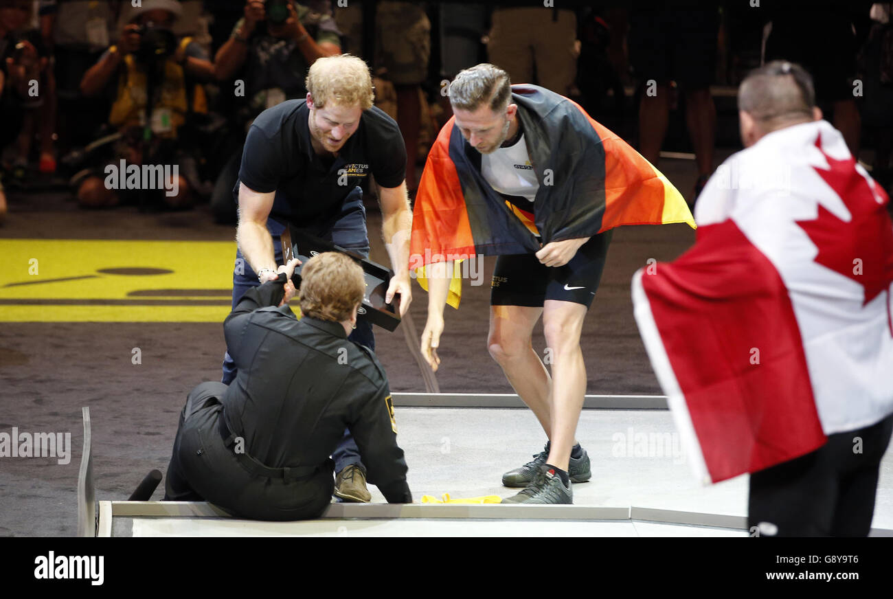 Prinz Harry hilft Anna Hall Mayzik, nachdem sie fiel, während er eine Silbermedaille an einen deutschen Athleten bei den Invictus Games 2016 bei ESPN Wide World of Sports in Orlando, Florida übergab. Stockfoto