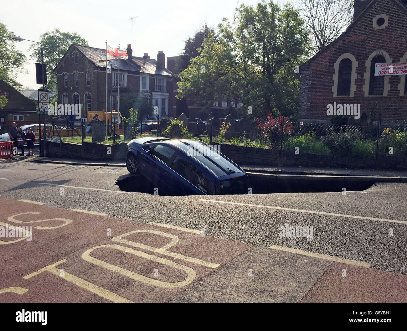 Ein Auto, das teilweise in einer Sinkhole in Woodland Terrace in Greenwich im Südosten Londons verschwunden ist. Stockfoto