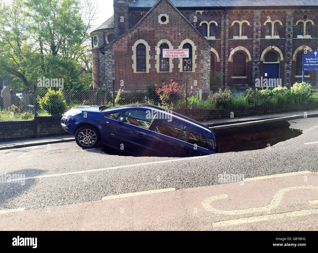 Ein Auto, das teilweise in einer Sinkhole in Woodland Terrace in Greenwich im Südosten Londons verschwunden ist. Stockfoto