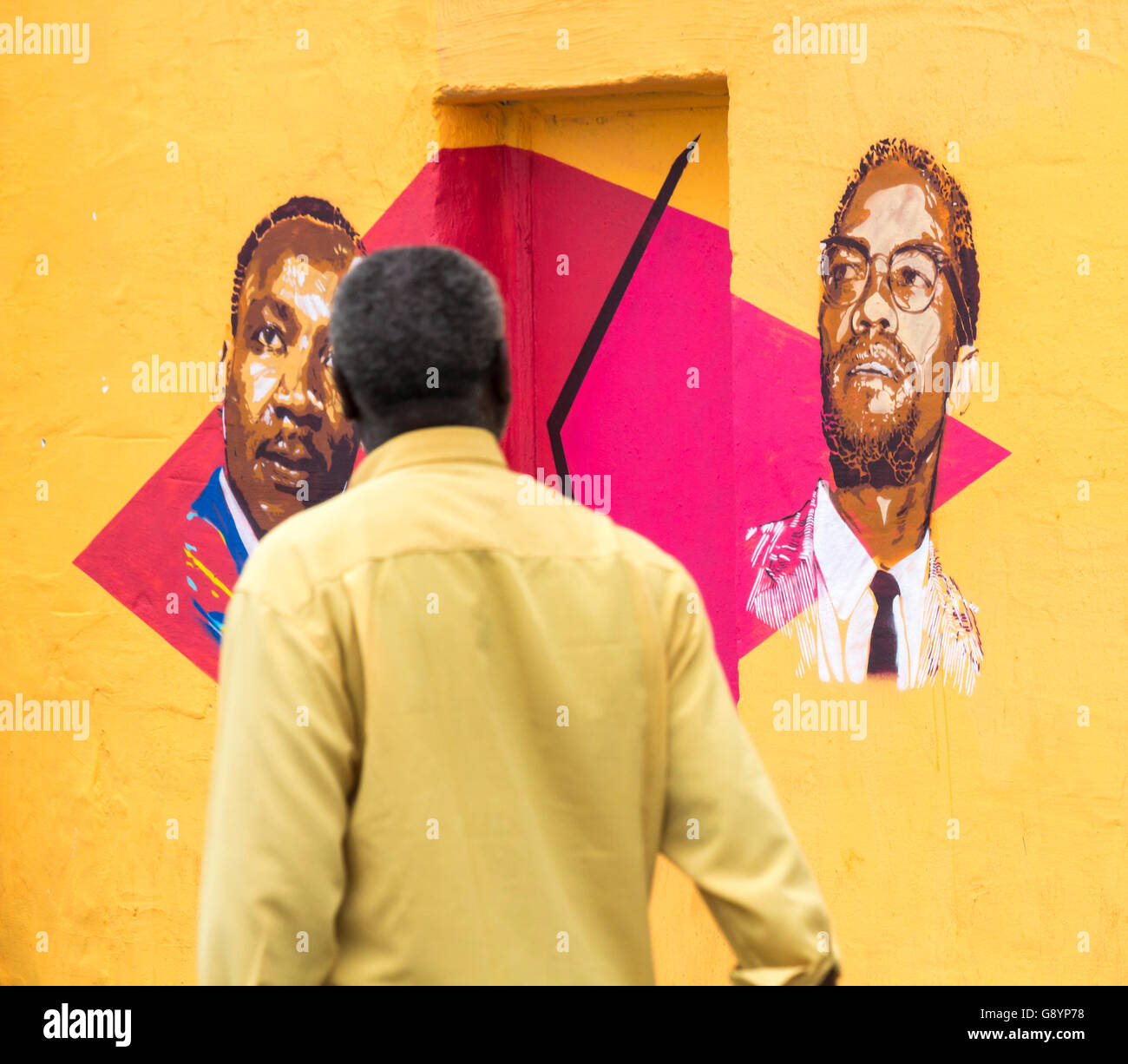 Las Palmas, Gran Canaria, Kanarische Inseln, Spanien, 30. Juni 2016. Ein Mann geht Vergangenheit eine Wand mit Bildern von Martin Luther King und Malcolm X lackiert. Die Graffiti an der Wand ein leerstehendes Gebäude viel ändert sich fast wöchentlich. Bildnachweis: Alan Dawson News/Alamy Live-Nachrichten Stockfoto