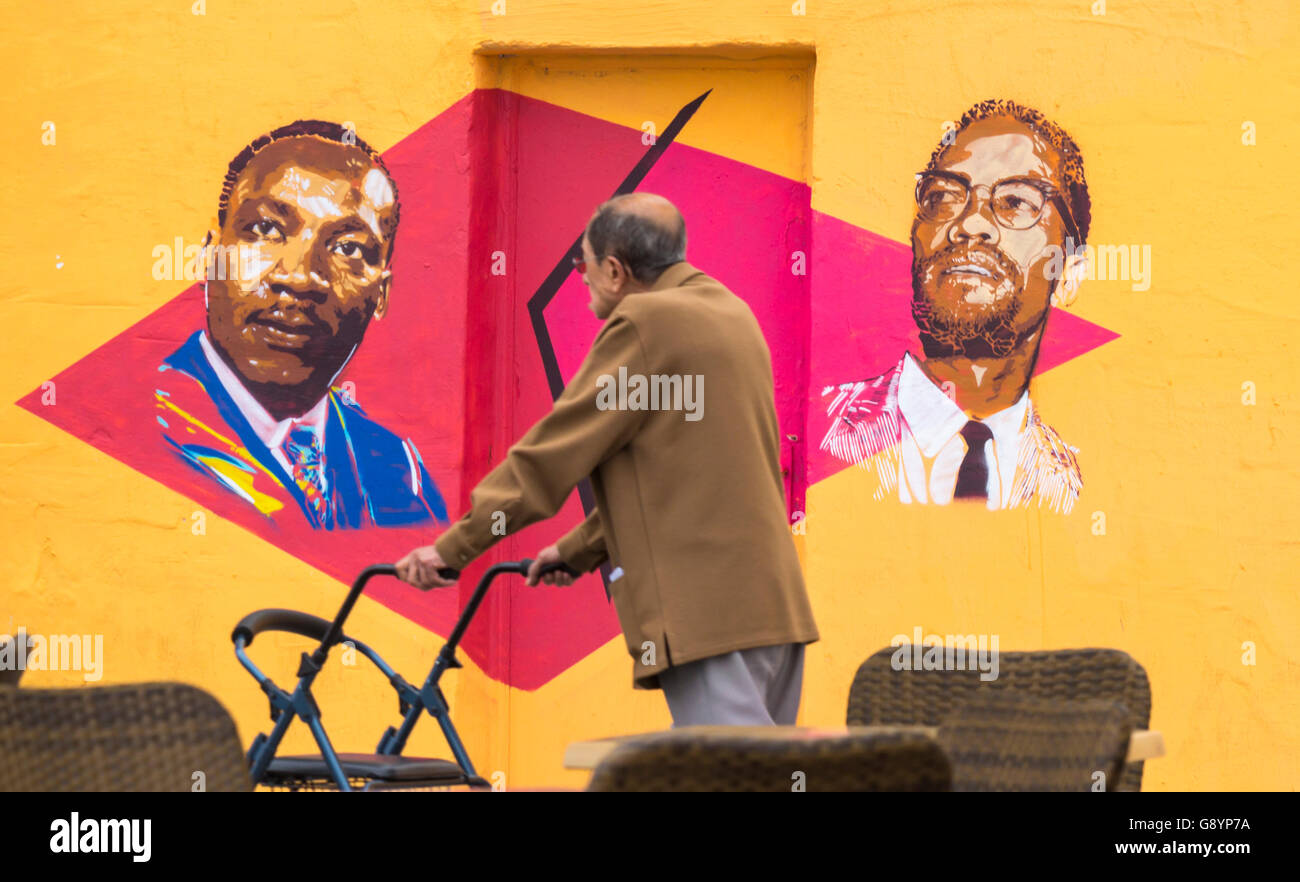 Las Palmas, Gran Canaria, Kanarische Inseln, Spanien, 30. Juni 2016. Ein Mann geht Vergangenheit eine Wand mit Bildern von Martin Luther King und Malcolm X lackiert. Die Graffiti an der Wand ein leerstehendes Gebäude viel ändert sich fast wöchentlich. Bildnachweis: Alan Dawson News/Alamy Live-Nachrichten Stockfoto