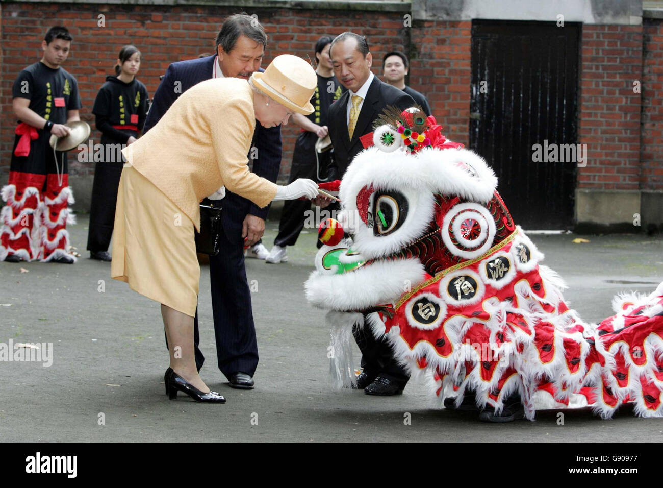 Die britische Königin Elizabeth II. Strichen einem Löwen bei der offiziellen Eröffnung des Camden Chinese Community Centre im Zentrum von London, Donnerstag, 3. November 2005, die Augen. DRÜCKEN Sie VERBANDSFOTO. Bildnachweis sollte lauten: Jeremy Selwyn/PA/NPA Rota. Stockfoto