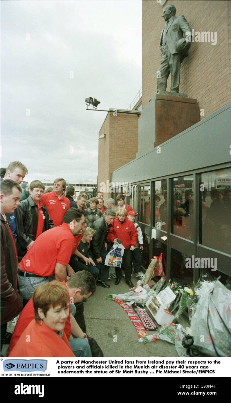 Eine Gruppe von Manchester United-Fans aus Irland zollt den Spielern und Beamten, die vor 40 Jahren bei der Münchner Luftkatastrophe unter der Statue von Sir Matt Busby getötet wurden, ihren Respekt Stockfoto