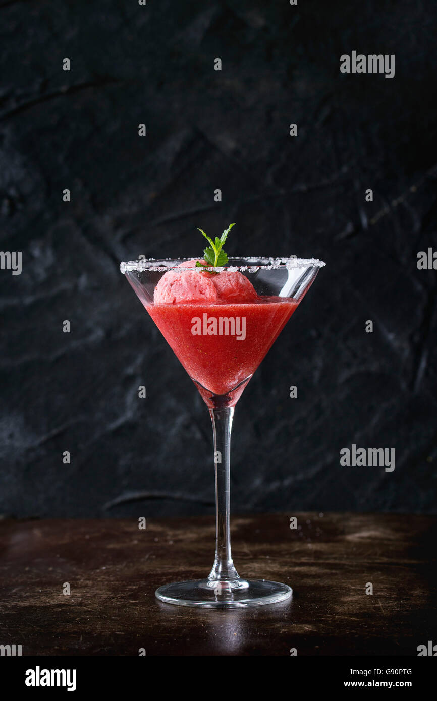 Gezuckert Cocktailglas Erdbeer Dessert, serviert auf dunklem Hintergrund mit frischer Minze-Sorbet. Mit Textfreiraum. Stockfoto