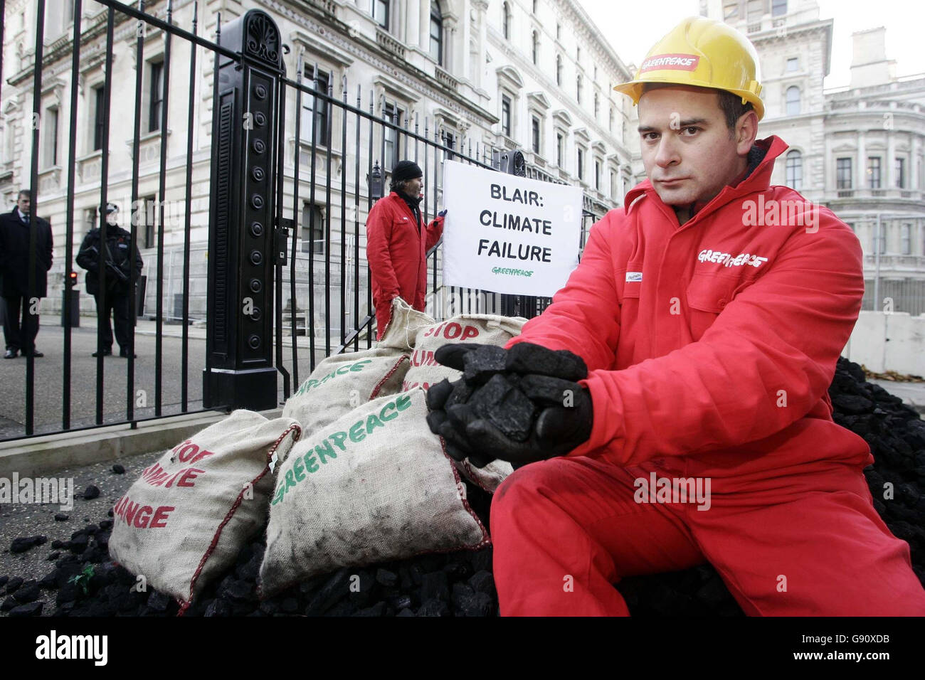 Greenpeace-Aktivisten blockieren einen der Eingänge zur Downing Street, London, Montag, 14. November 2005, aus Protest gegen das Versagen des Premierministers, die globale Erwärmung zu bekämpfen. Die Aktivisten informierten die Polizei, was sie tun würden, bevor gegen 7.30 Uhr ein Lastwagen mit dem Slogan „Blair – Climate Failure“ die Kohlenhügel vor den Toren von Tony Blairs Residenz kippte. Siehe PA Geschichte POLITIK Kohle. DRÜCKEN SIE VERBANDSFOTO. Bildnachweis sollte lauten: Andrew Parsons/PA Stockfoto