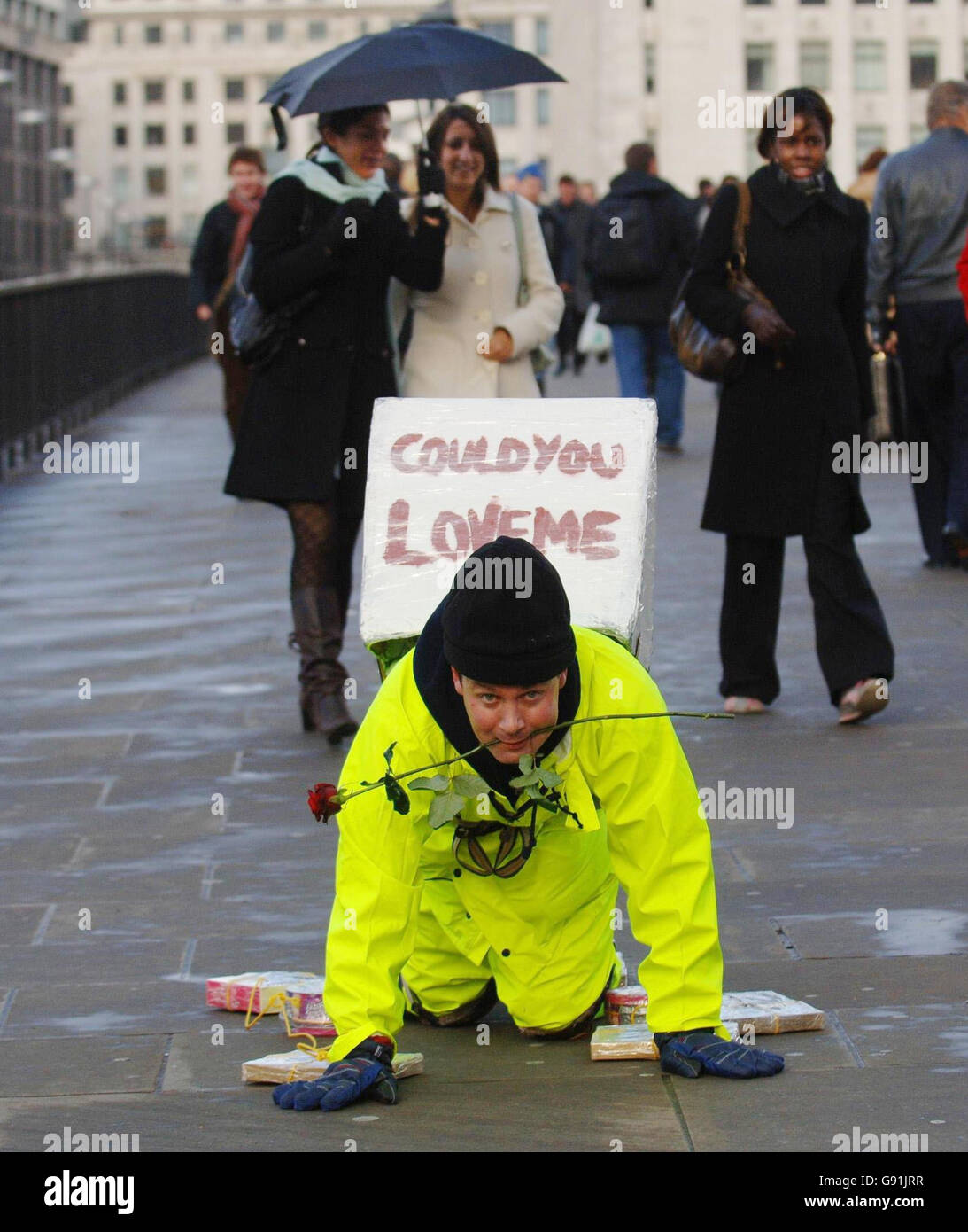 Der Künstler Mark McGowan krabbelt über die London Bridge am Freitag, den 2. Dezember 2005, mit Schachteln mit Pralinen an Händen und Füßen und einer Rose zwischen seinen Zähnen. Er startete seinen Versuch, 60 Meilen von London nach Canterbury zu kriechen, beginnend mit dem zweiten Weihnachtsfeiertag: Er sagt, er tue es für diejenigen, die Weihnachten allein verbringen. DRÜCKEN SIE VERBANDSFOTO. Der Bildnachweis sollte lauten: Fiona Hanson/PA. Stockfoto
