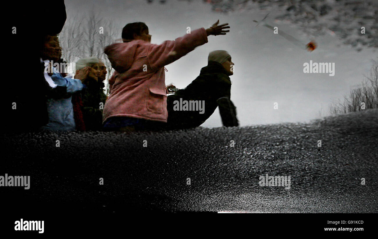 Die Reflexion eines jungen Trauers wird gezeigt, als sie Blumen auf George Best's Sarg werfen, als er am Samstag, 3. Dezember 2005, in den Cemetary Ballygowan von Roselawn eindringt. Die Welt des Fußballs hat heute ihre letzte Ehre erwiesen, als Best, einer der größten Spieler aller Zeiten, zur Ruhe kam. Best, 59, starb letzten Freitag im Londoner Cromwell Hospital. Siehe PA Story FUNERAL Best. DRÜCKEN SIE VERBANDSFOTO. Das Foto sollte lauten: Julien Behal/PA. Stockfoto