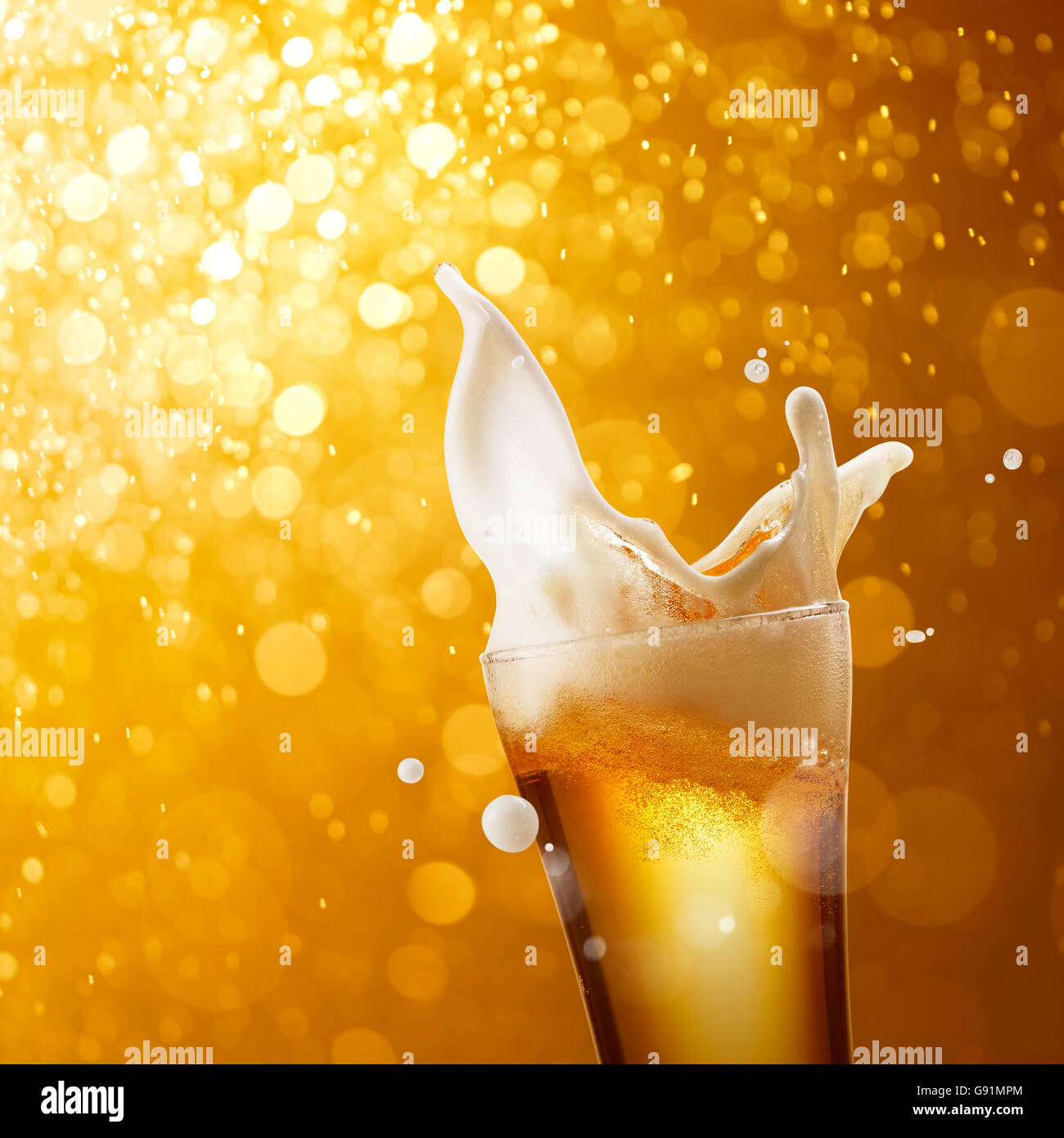 plätschernden Bier vor goldenen Bokeh Hintergrund Stockfoto