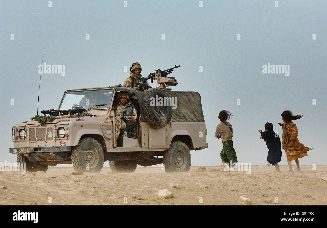 Drei irakische Kinder betrachten Soldaten des RAF-Regiments mit 1 Squadron während einer Patrouille in der arabischen Marschregion bei Basra. Stockfoto