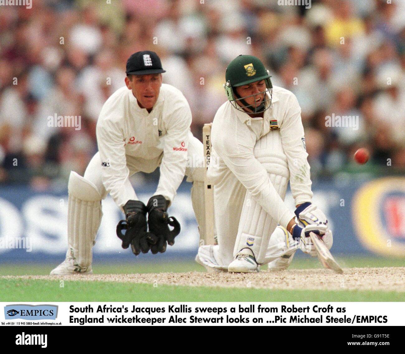 Der Südafrikaner Jacques Kallis fegt einen Ball von Robert Croft Wie England Wicketkeeper Alec Stewart schaut auf Stockfoto