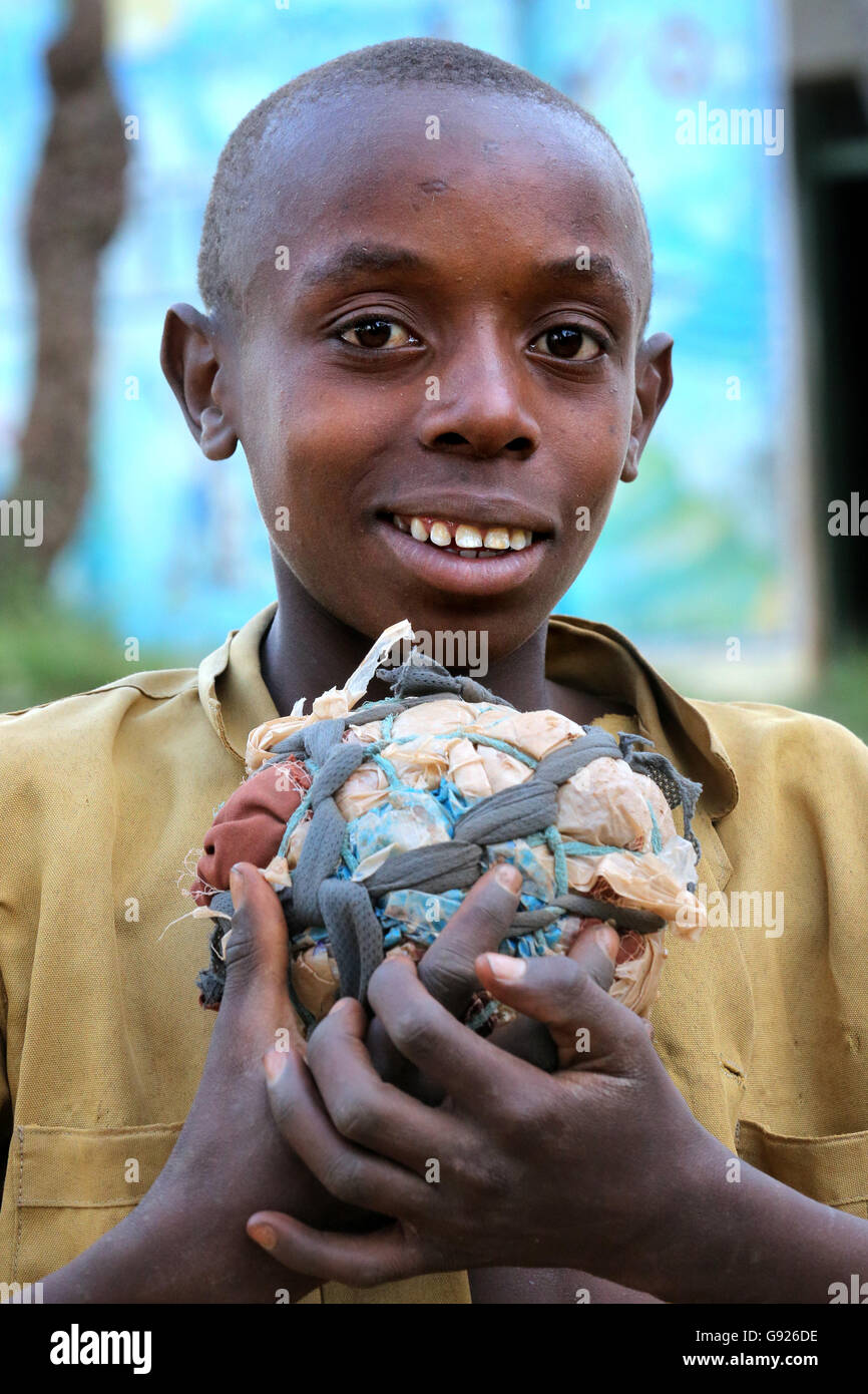 Junge (12 Jahre) mit seinem selbstgebauten Fußball gemacht aus Stofffetzen und Plastiktüten in einem Dorf in der Nähe von Ruhengeri, Ruanda, Afrika Stockfoto