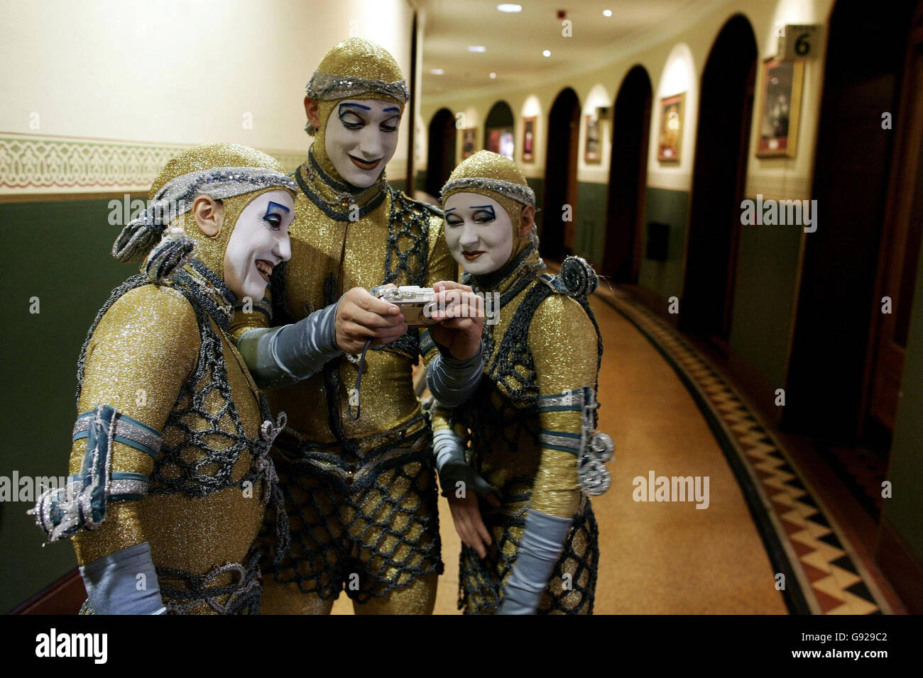 Die Darsteller des Cirque Du Soleil sehen sich die Bilder hinter der Bühne der Royal Albert Hall an, während sie am Dienstag, den 3. Januar 2006, eine Fotoschau für die Alegria des Cirque Du Soleil machen. Alegr'a, das seinen Namen von einem spanischen Wort für Jubel trägt, ist eine Renaissance der Träume mit einer barocken Mischung aus erstaunlicher Akrobatik, beeindruckenden Luftaufführungen, außergewöhnlicher Beleuchtung und einem aufwendigen Bühnenbild. DRÜCKEN SIE VERBANDSFOTO. Bildnachweis sollte lauten: Andrew Parsons/PA Stockfoto