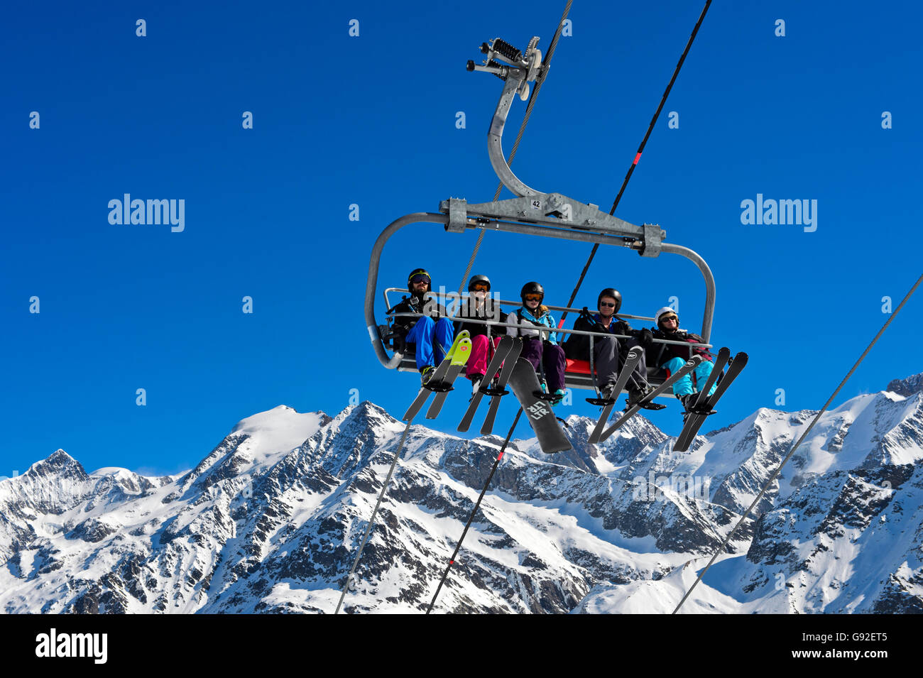 Skifahrer auf einer Sesselbahn im Skigebiet Les Contamines-Montjoie, Mont-Blanc-Massiv hinter, Haute-Savoie, Frankreich Stockfoto