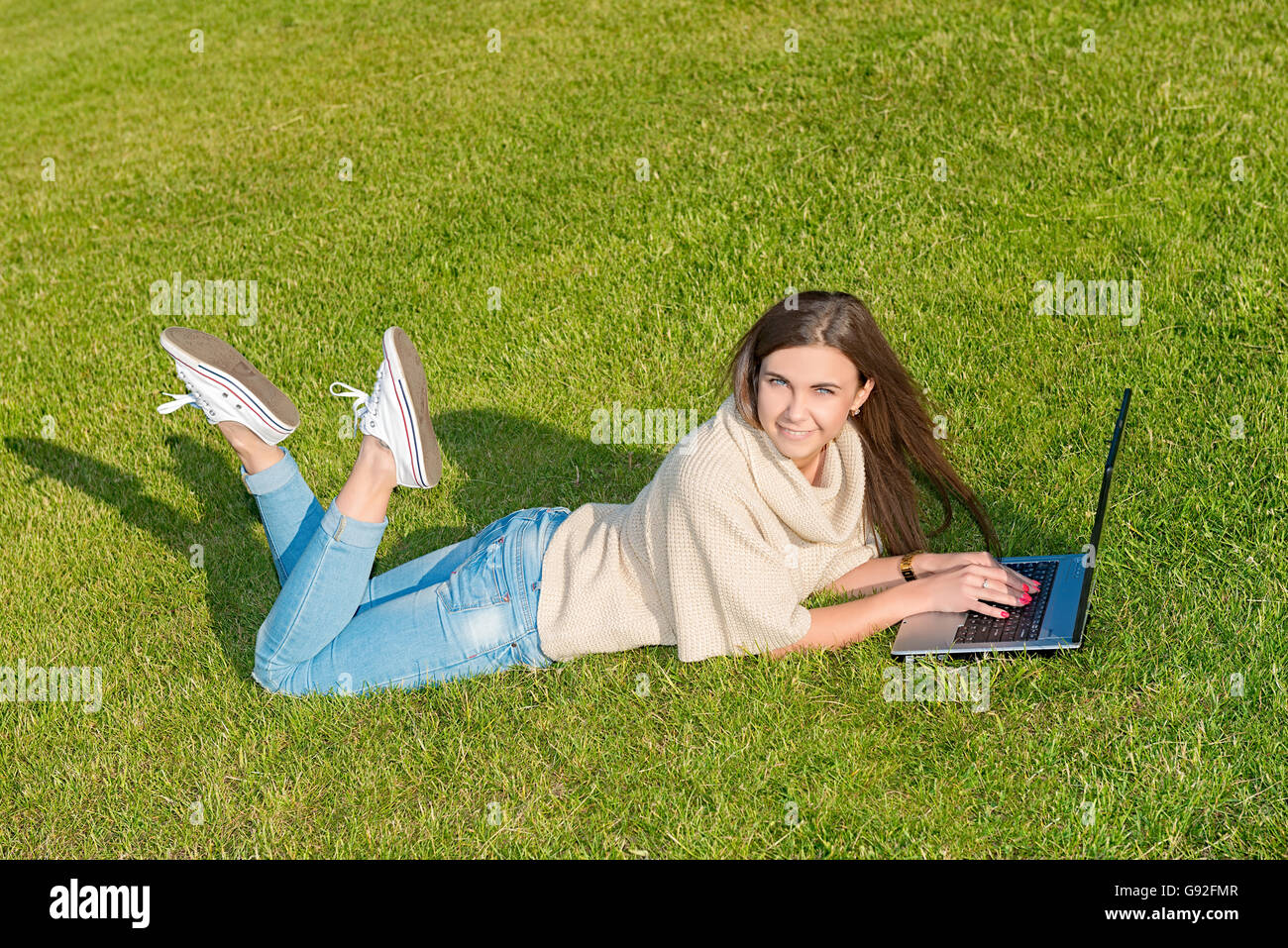 glückliche junge Studentin Frau mit Laptop im Stadtpark Stockfoto