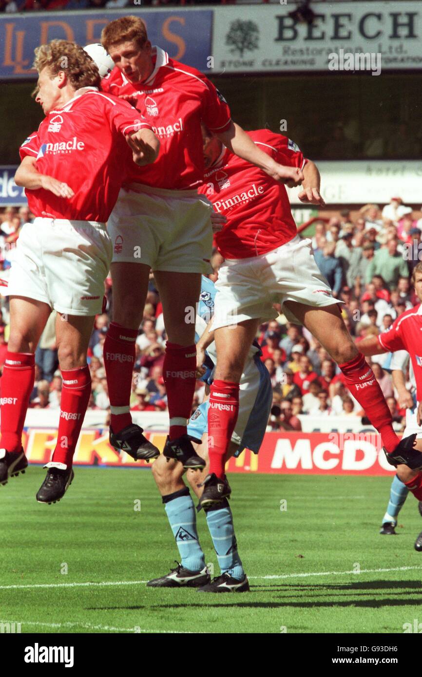 Fußball - FA Carling Premiership - Nottingham Forest / Coventry City. Die Schotte Gemmill (links) und Craig Armstrong (Mitte) von Nottingham Forest springen, um ein Kreuz zu räumen Stockfoto