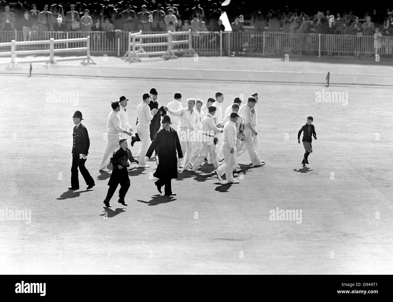 Der englische Jim Laker (r) führt seine Teamkollegen vom Spielfeld weg Nach der Einnahme alle zehn der zweiten Innings Australiens Wickets zu Gewinnen Sie das Spiel Stockfoto