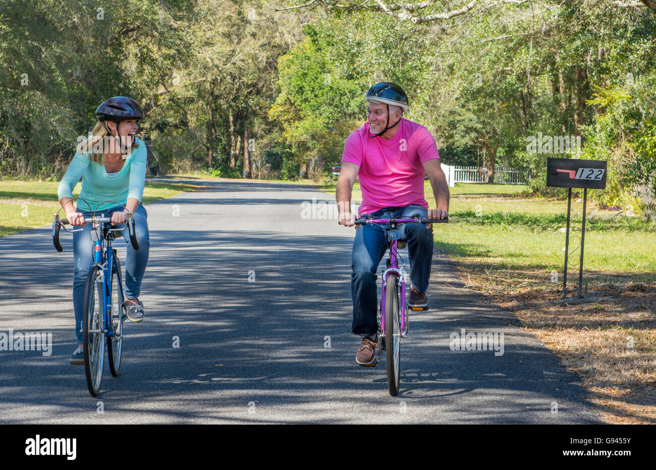 paar im Alter von 40er und 50er Jahre Fahrrad zu Hause in der Nachbarschaft Sicherheit Helme Übung gesunden Lebensstil Pflege Liebe Modell veröffentlicht, Stockfoto