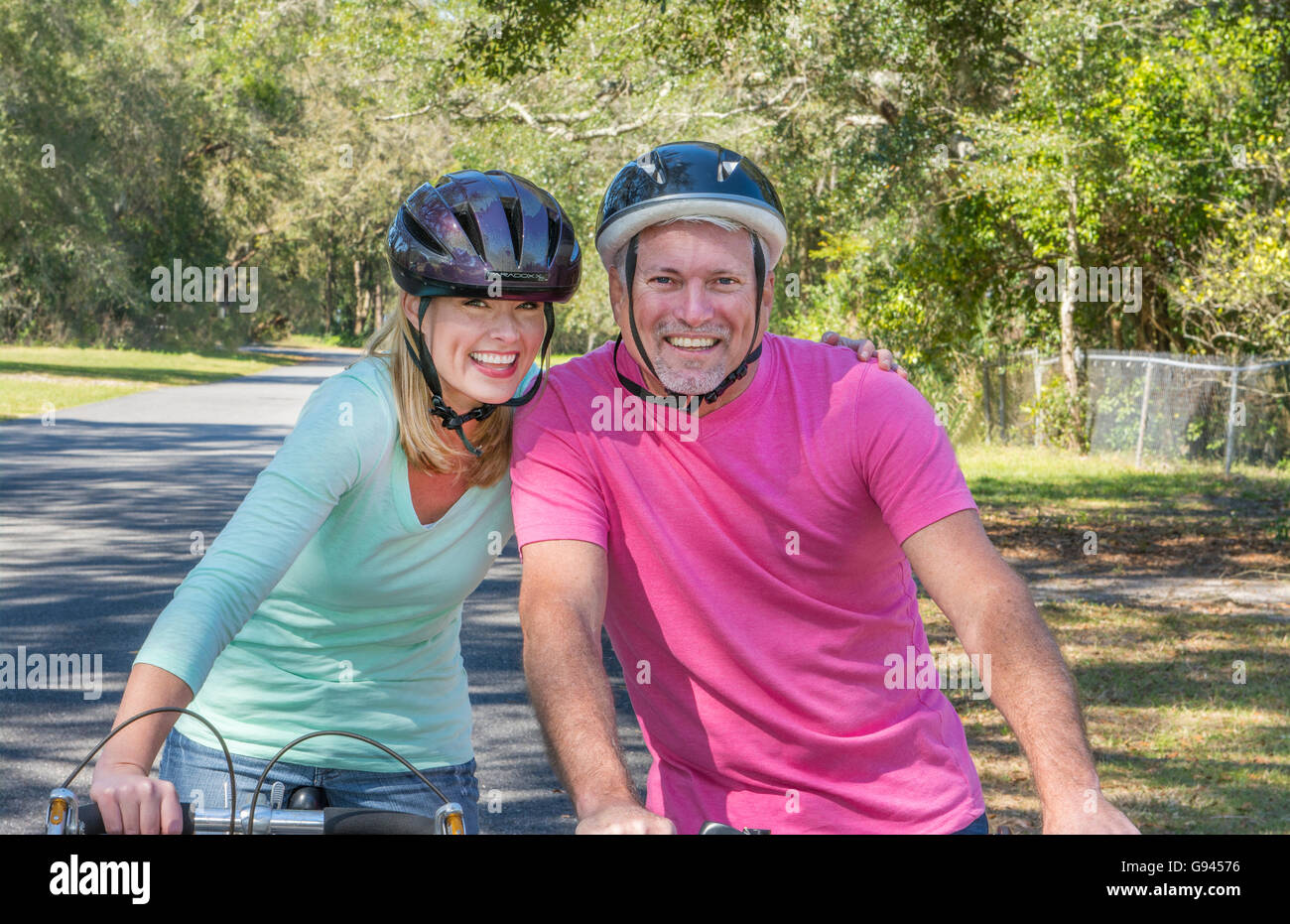 paar im Alter von 40er und 50er Jahre Fahrrad zu Hause in der Nachbarschaft Sicherheit Helme Übung gesunden Lebensstil Pflege Liebe Modell veröffentlicht, Stockfoto
