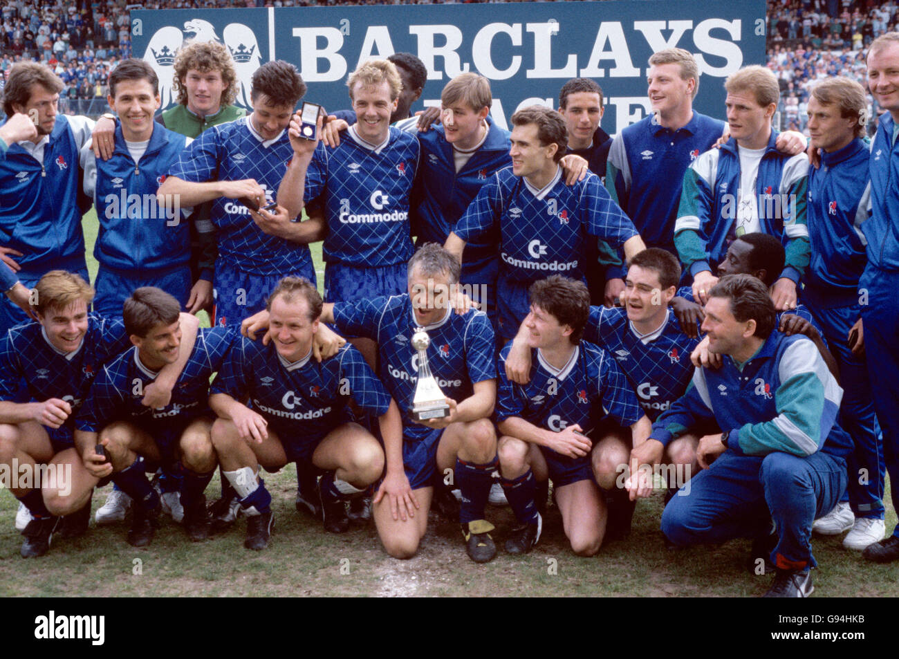 Chelsea Spieler feiern mit der Division zwei Meisterschaft Trophäe nach dem Sieg über den Titel mit einem 3-1 Sieg: (Hintere Reihe, l-r) Dave Mitchell, Kevin Hitchcock, Dave Beasant, Joey McLoughlin, Kerry Dixon, ?, ? Tony Dorigo, ?, ?, Gordon Durie, John Bumstead, ?; (erste Reihe, l-r) Gareth Hall, Kevin Wilson, Peter Nicholas, Graham Roberts, Kevin McAllister, Steve Clarke, Clive Wilson, Assistant Manager Ian Porterfield (vorne) Stockfoto