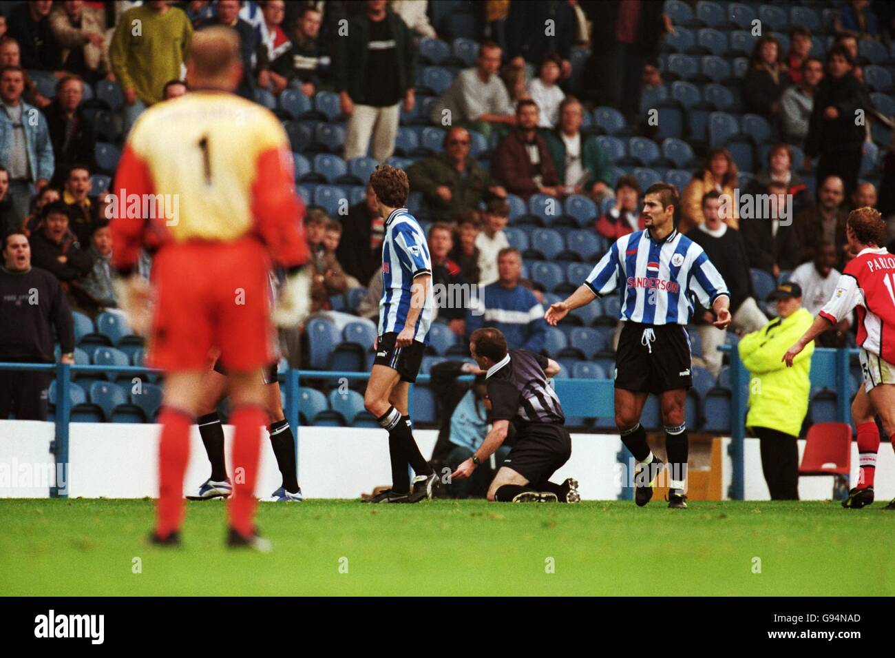 Fußball - FA Carling Premiership - Sheffield Mittwoch / Arsenal. Paolo Di Canio (versteckt) vom Mittwoch in Sheffield schiebt Schiedsrichter Paul Alcock (Mitte) nach seiner Absendung zu Boden Stockfoto