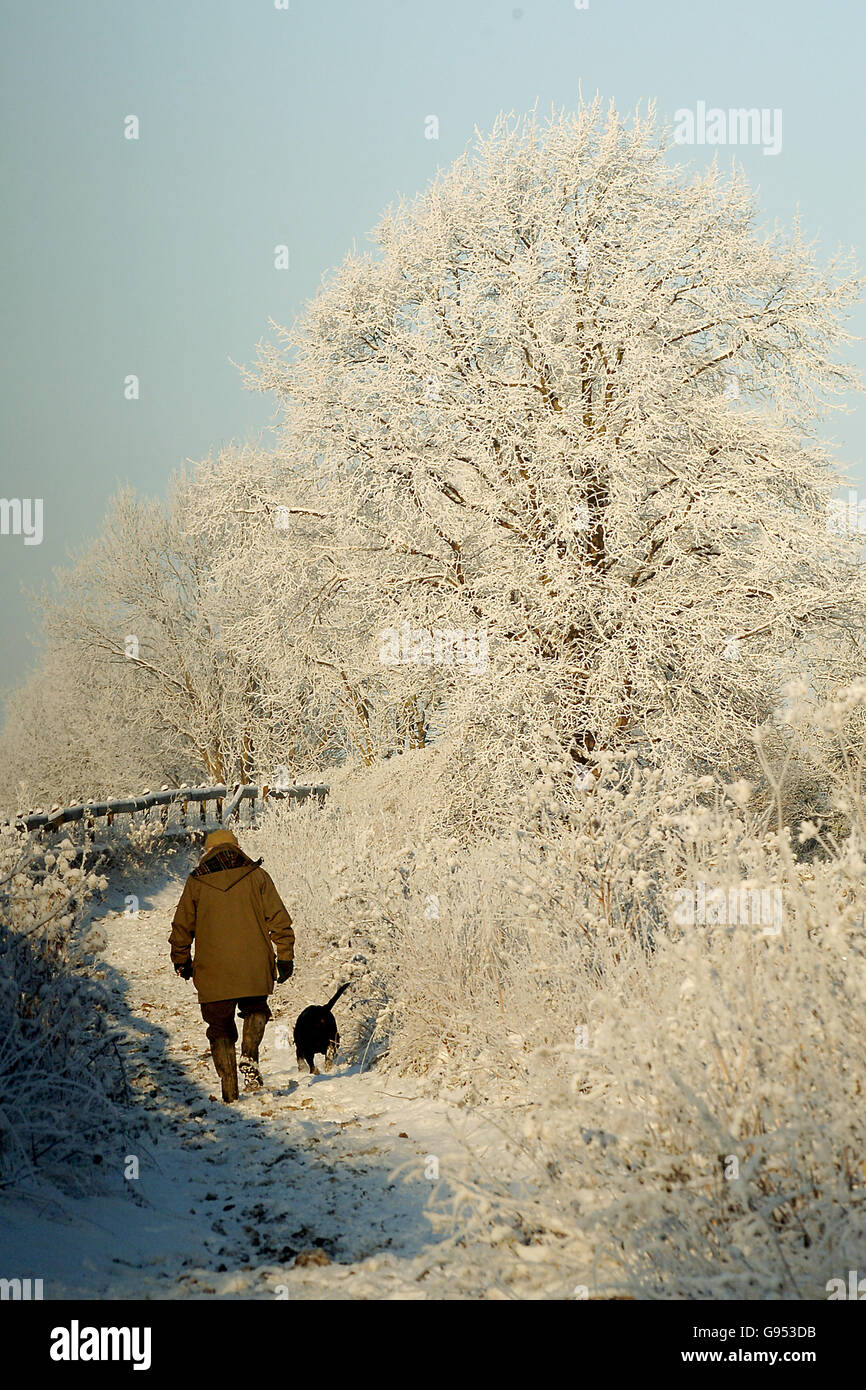 Ein Mann geht seinen Hund am Mittwoch, den 28. Dezember 2005, durch den Schnee bei Pickering. DRÜCKEN SIE VERBANDSFOTO. Das Foto sollte lauten: John Giles/PA. Stockfoto