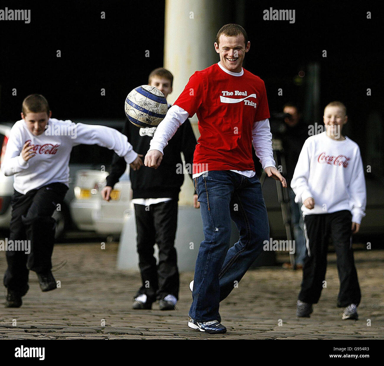 Manchester United Fußballspieler Wayne Rooney spielt Straßenfußball mit den Gewinnern eines Coca-Cola Wettbewerbs im Science and Industry Museum in Manchester. Stockfoto
