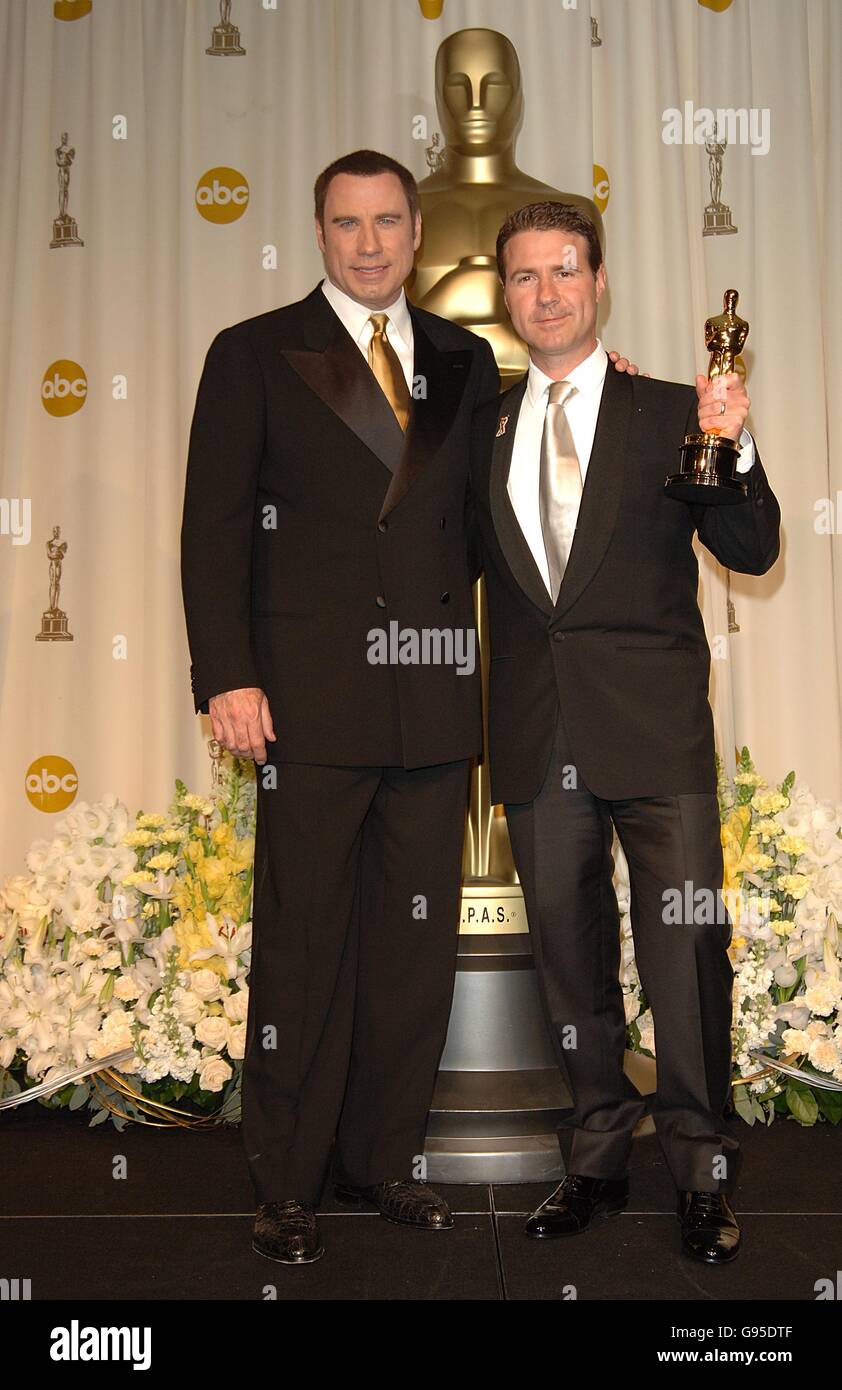 Academy Awards – Oscars – Kodak Theatre. John Travolta mit Dion Beebe und seinem Preis für seine Leistungen im Bereich der Kinematographie für Memoiren einer Geisha Stockfoto