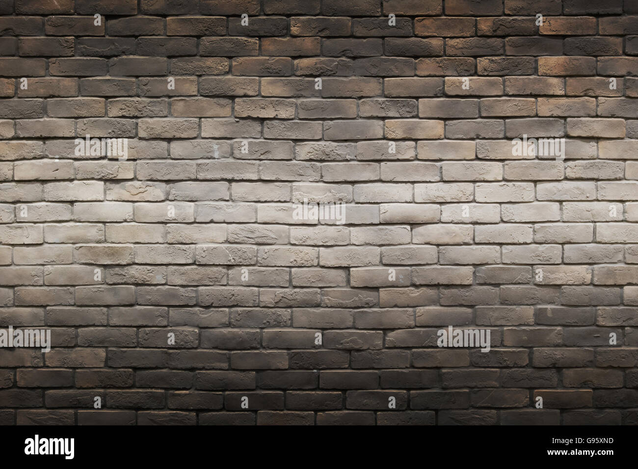 dunkel schwarz braun grau Ziegel Wand Hintergrund mit horizontalen Gradienten Lichtlinie in der Mitte Stockfoto