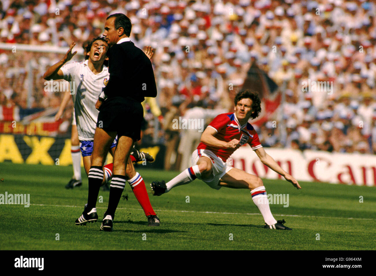 Englands Steve Coppell überfällt Michel Platini aus Frankreich, aber der Schiedsrichter verschließt die Augen für den Vorfall. Schiedsrichter ist Antonio Jose da Silva Garrido aus Portugal. Stockfoto