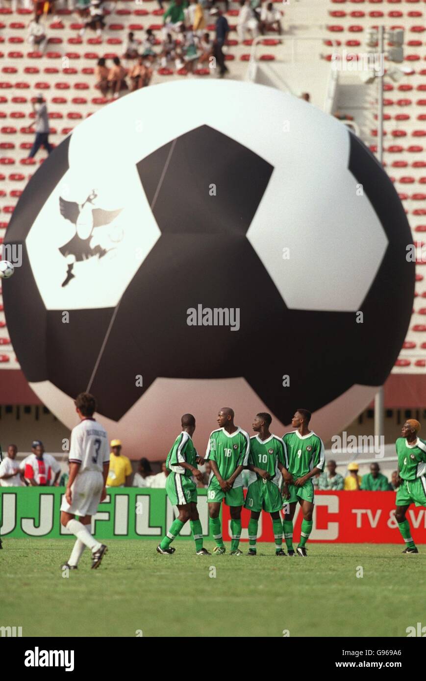 Die nigerianische Verteidigungsmauer steht vor einem riesigen Fußball mit einem Bild von Pego, dem fliegenden Adler, dem offiziellen Maskottchen des Turniers Stockfoto
