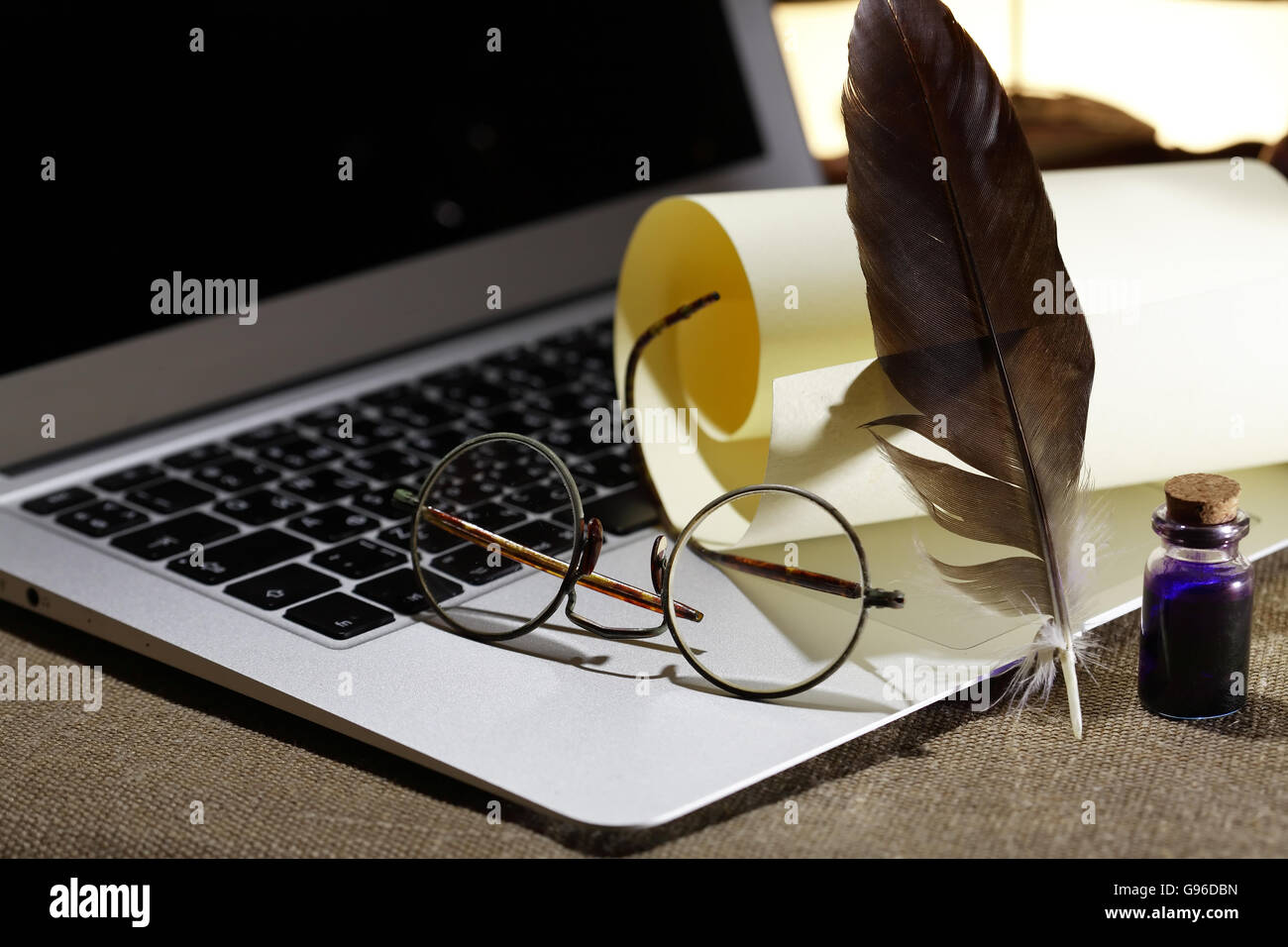 Moderne Literatur. Stillleben mit Schriftrolle und Feder auf modernen laptop Stockfoto