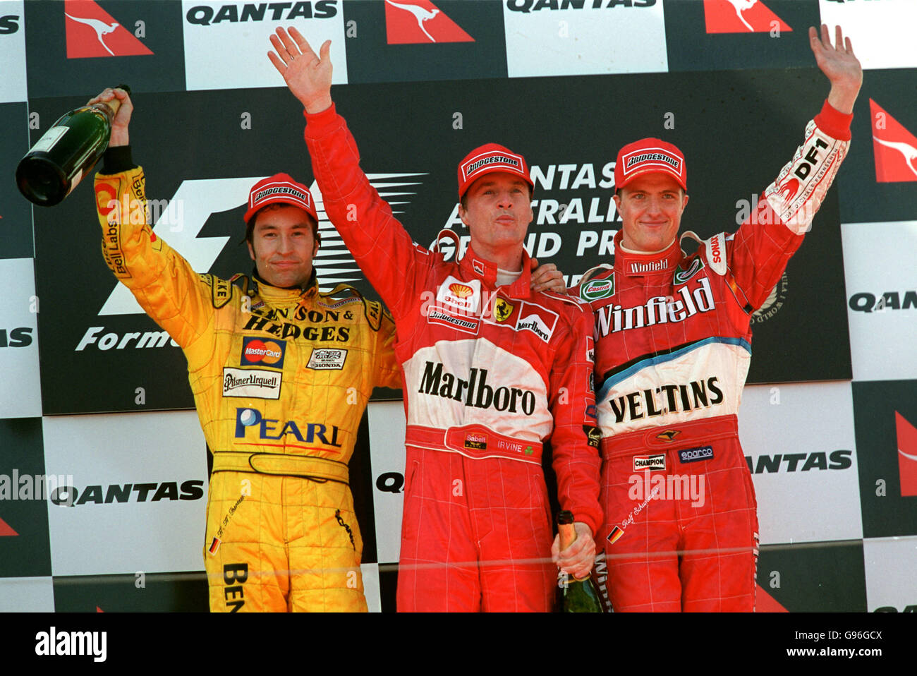 Eddie Irvine steht mit Heinz-Harald Frentzen (l) und Ralf Schumacher (r) nach dem Sieg in Melbourne ganz oben auf dem Podium. Stockfoto