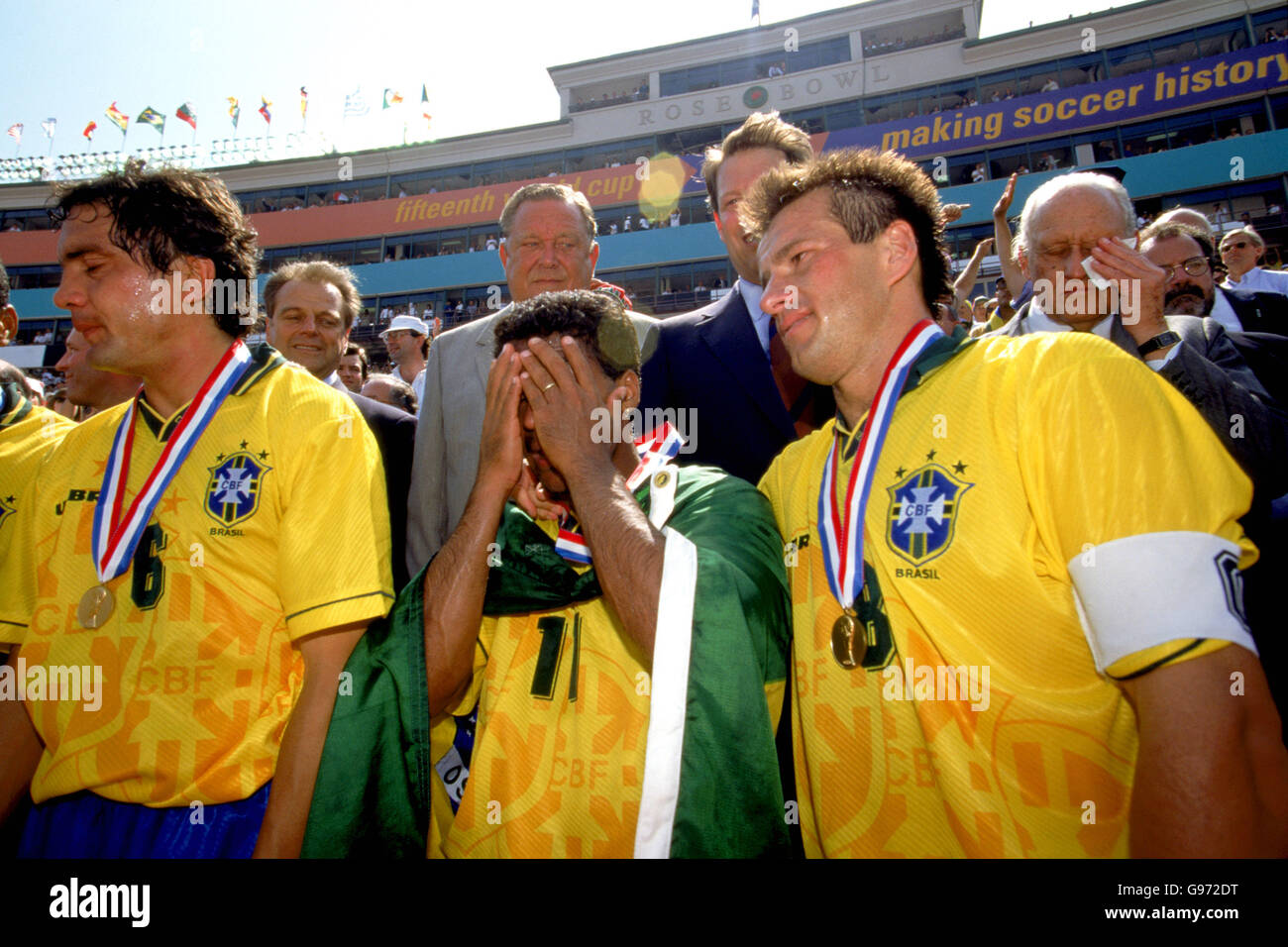 Brasilianischer Kapitän Dnicht (rechts) legt seinen Arm um Romario (Mitte), der nach dem vierten Weltcup-Finalsieg Brasiliens von Emotionen überwältigt ist. Joao Havelange (rechts, hinten), der brasilianische und FIFA-Vorsitzende, ist ebenfalls zerreißt, als Lennart Johansson (zweites l, hinten) und US-Vizepräsident Al Gore (zweites r, hinten) untätig darauf blicken Stockfoto