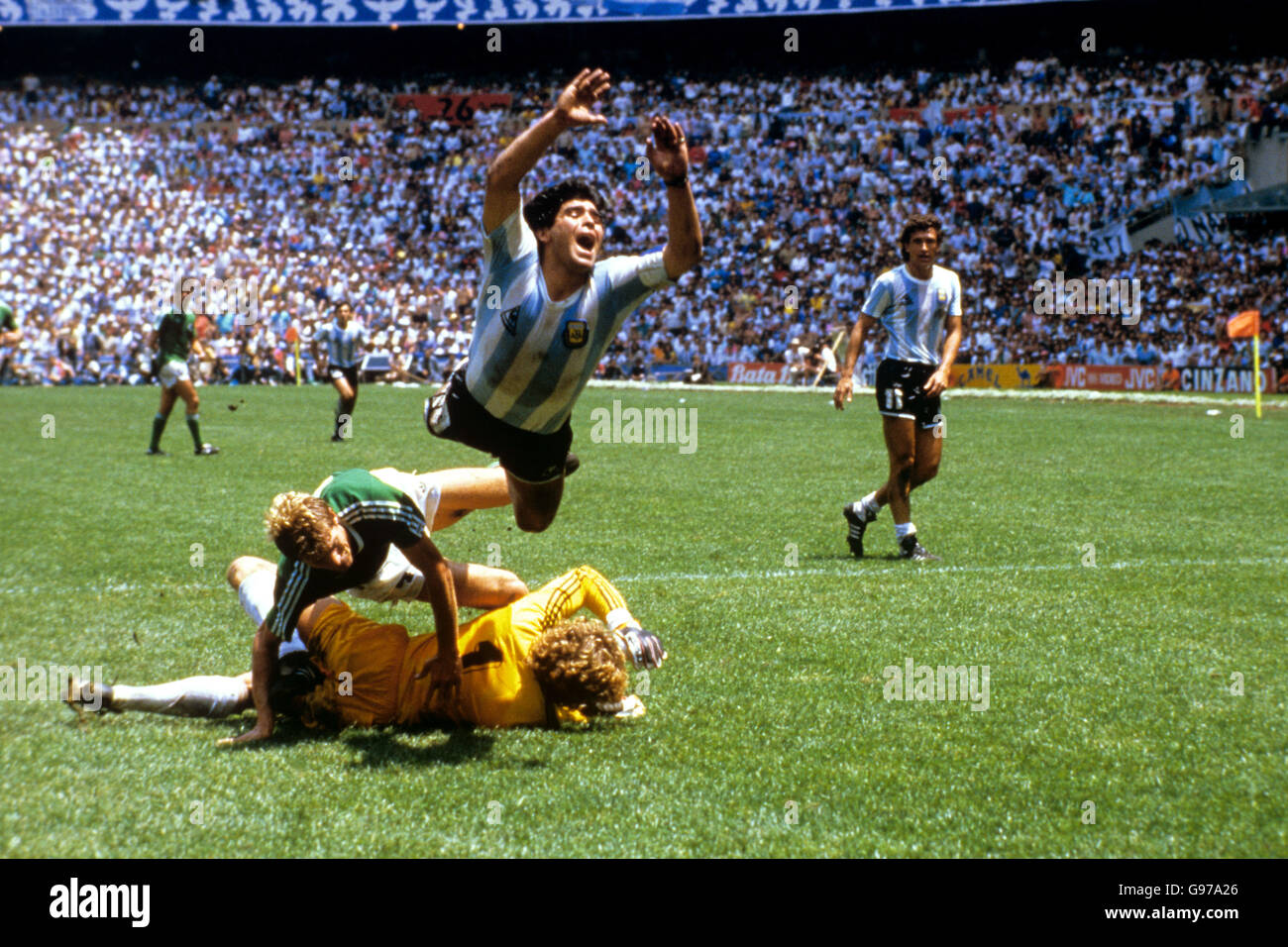 Fußball - Weltmeisterschaft Mexiko 1986 - Finale - Argentinien gegen Westdeutschland. Argentiniens Diego Maradona (oben) fliegt nach einer Herausforderung durch Westdeutschland-Torhüter Harald Schumacher (am Boden) durch die Luft Stockfoto