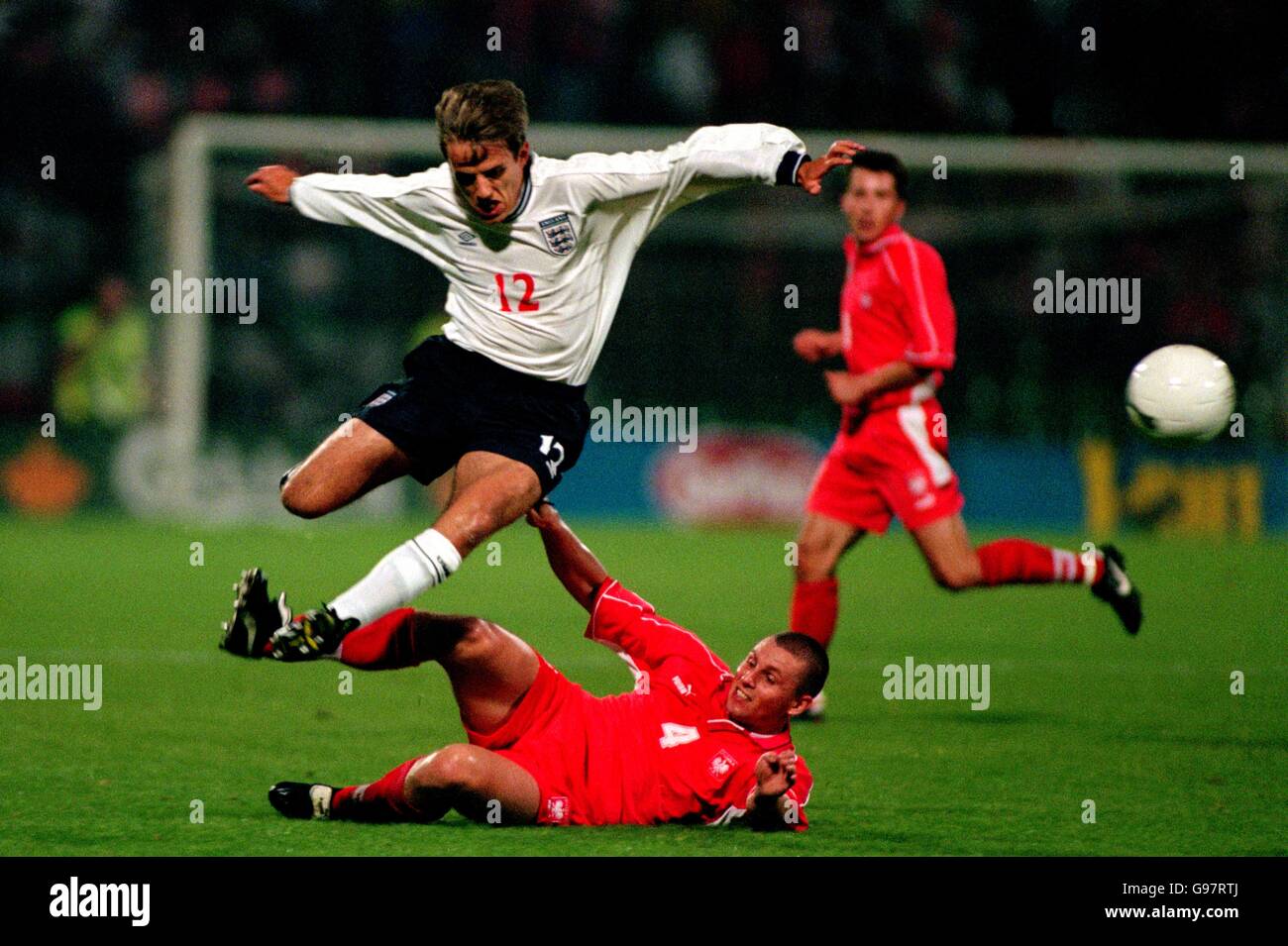 Fußball - Euro 2000 Qualifikation - Gruppe fünf - Polen gegen England. Der englische Philip Neville springt vom polnischen Rafal Siadaczka ins Tackle Stockfoto
