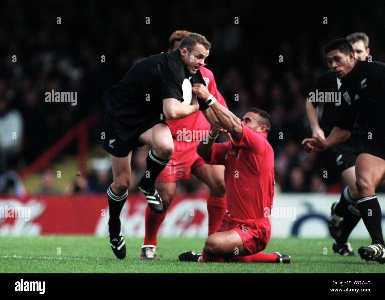 Rugby Union - Rugby-Weltmeisterschaft 99 - Pool B - Neuseeland / Tonga. Tevita Tiueti von Tonga versucht, den neuseeländischen Christian Cullen niederzureißen Stockfoto