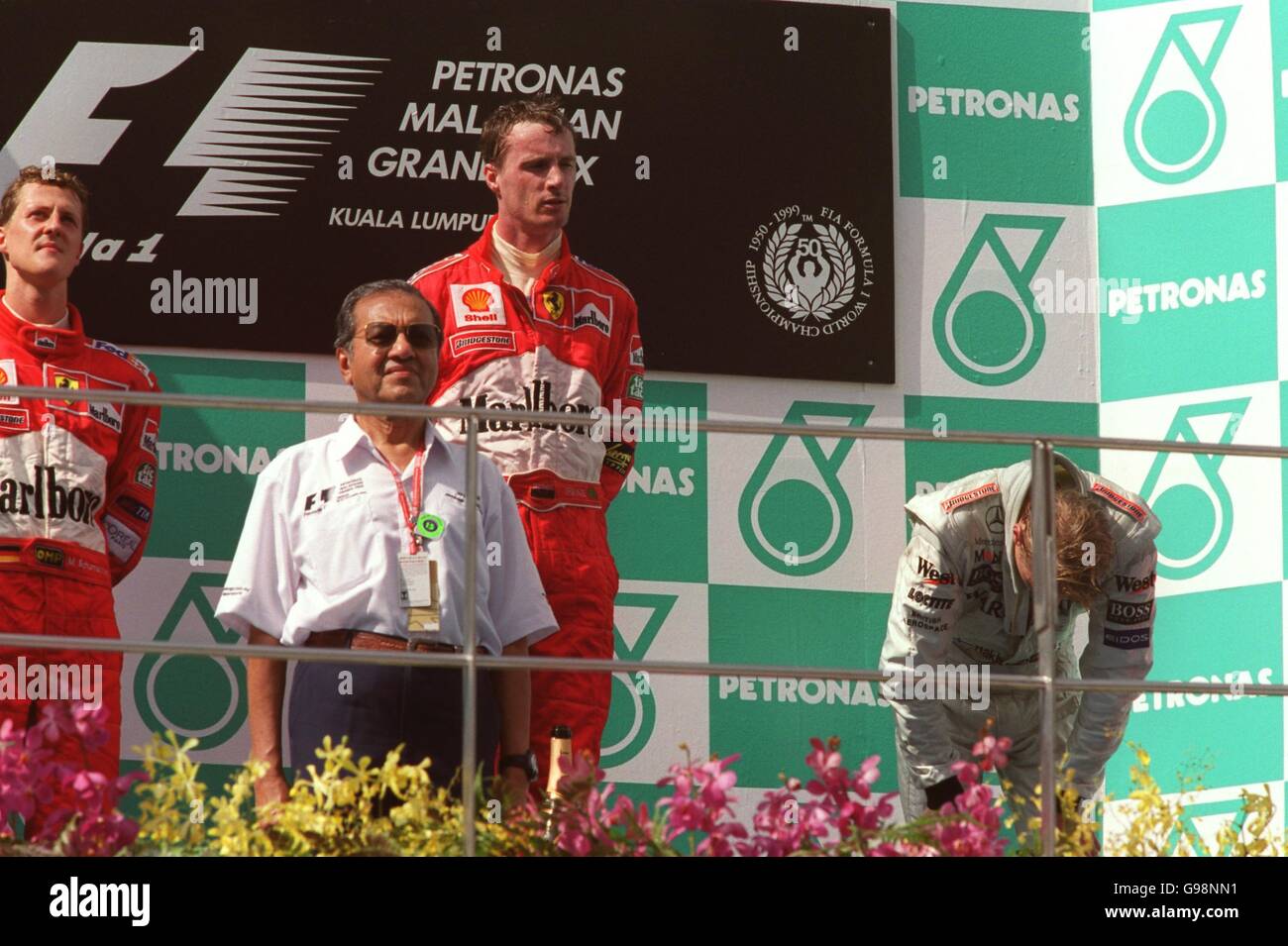 Formel-1-Autorennen - Großer Preis Von Malaysia. Ein glücklicher Eddie Irvine auf dem Siegerpodest, als Mika Hakkien vor Erschöpfung umgekickt ist Stockfoto