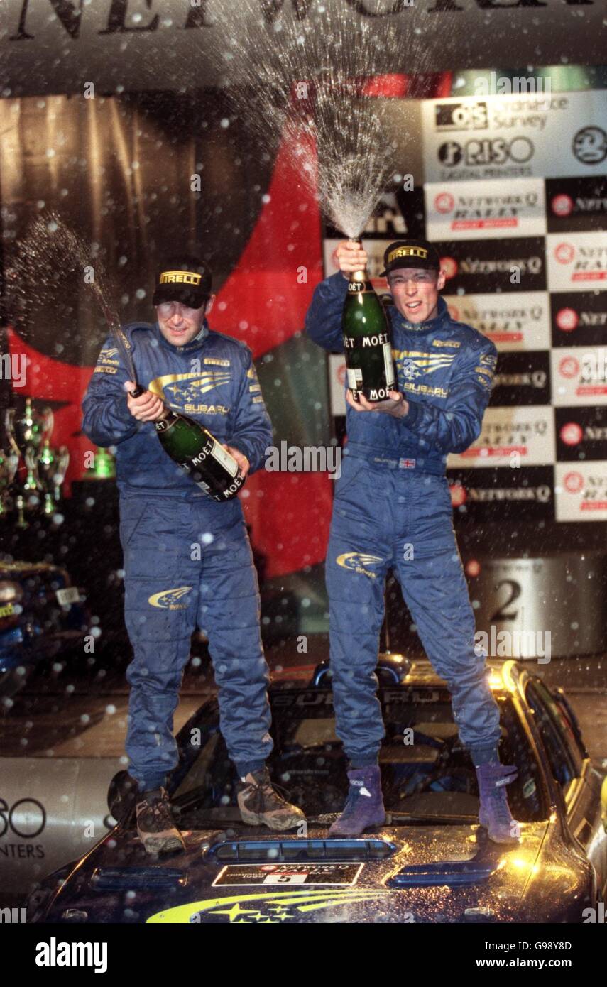 L-R: Co-Fahrer Robert Reid und Richard Burns feiern den Gewinn der Network Q Rally 1999 Stockfoto