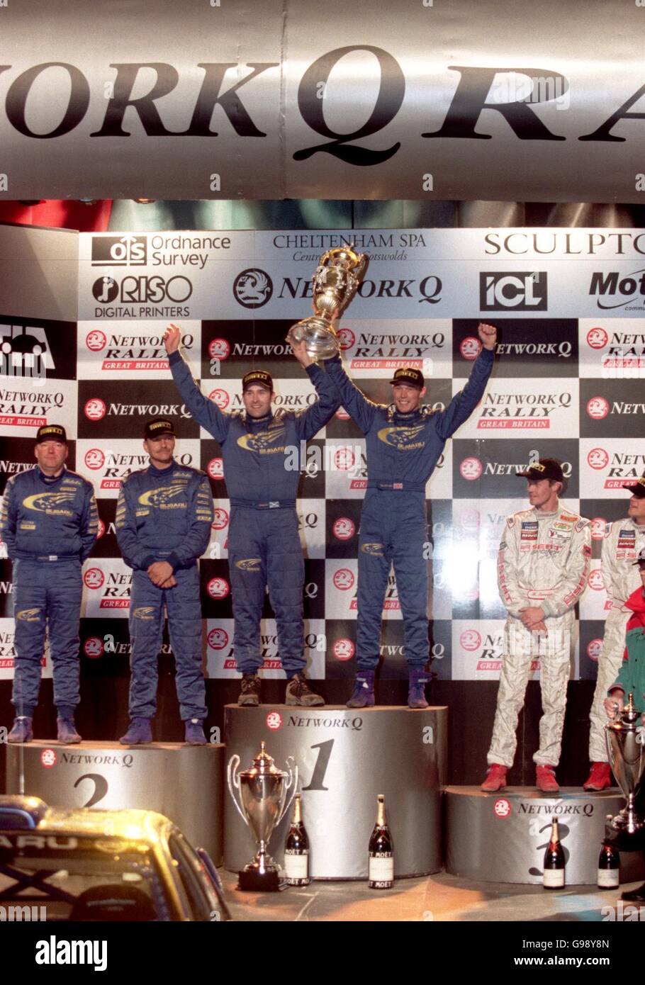 L-R (Mitte): Beifahrer Robert Reid und Fahrer Richard Burns feiern den Gewinn der Network Q Rally 1999 Stockfoto