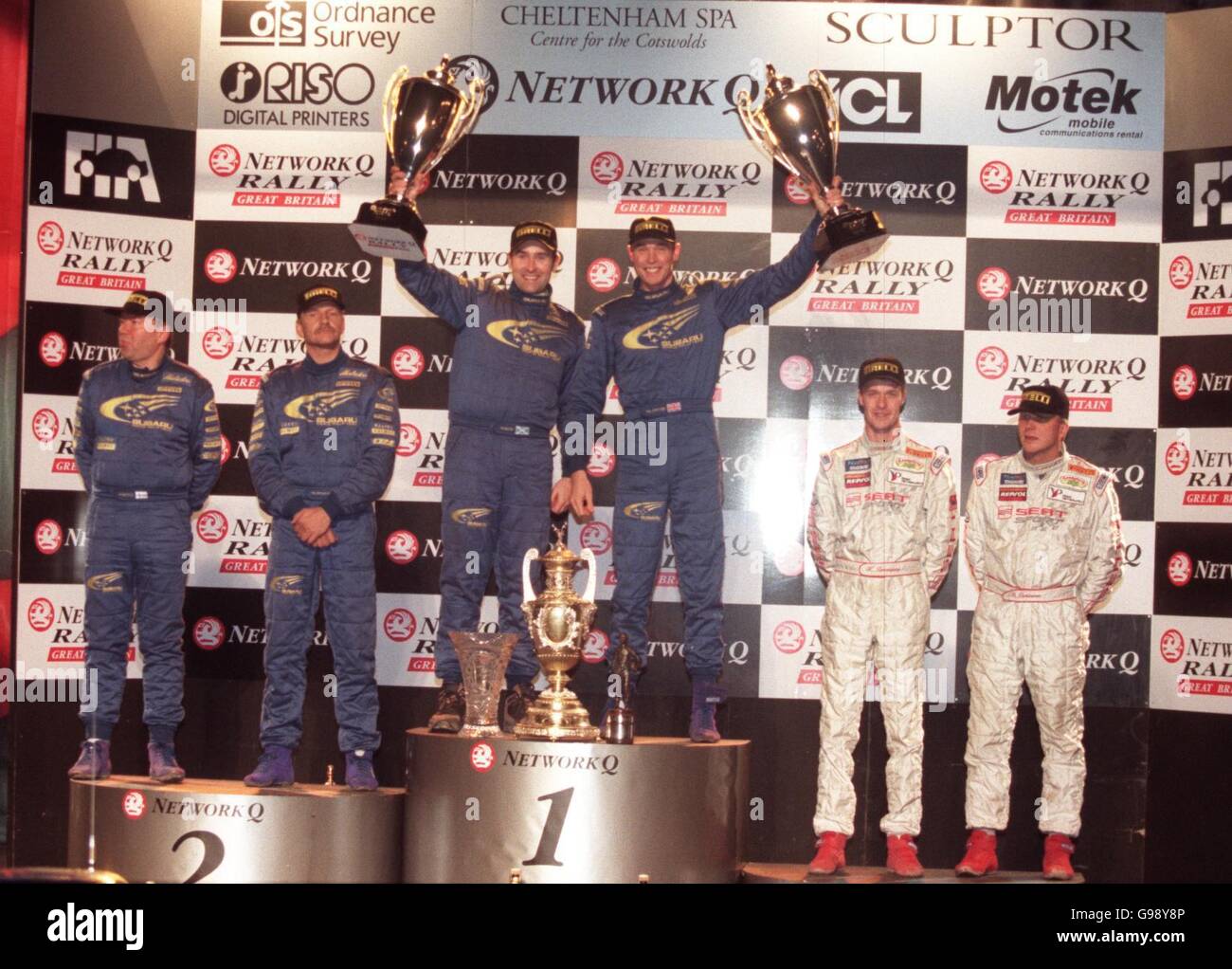 L-R (Mitte): Beifahrer Robert Reid und Fahrer Richard Burns feiern den Gewinn der Network Q Rally 1999 Stockfoto