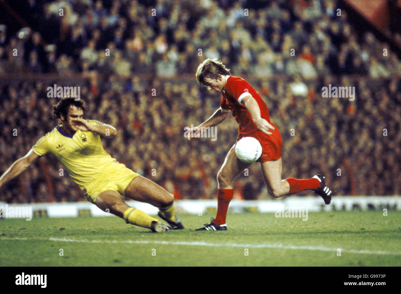 Fußball - Europameisterschaft - erste Runde zweite Etappe - Liverpool gegen Nottingham Forest. Larry Lloyd von Nottingham Forest (links) rutscht ein, um Liverpools Kenny Dalglish (rechts) zu bekämpfen Stockfoto