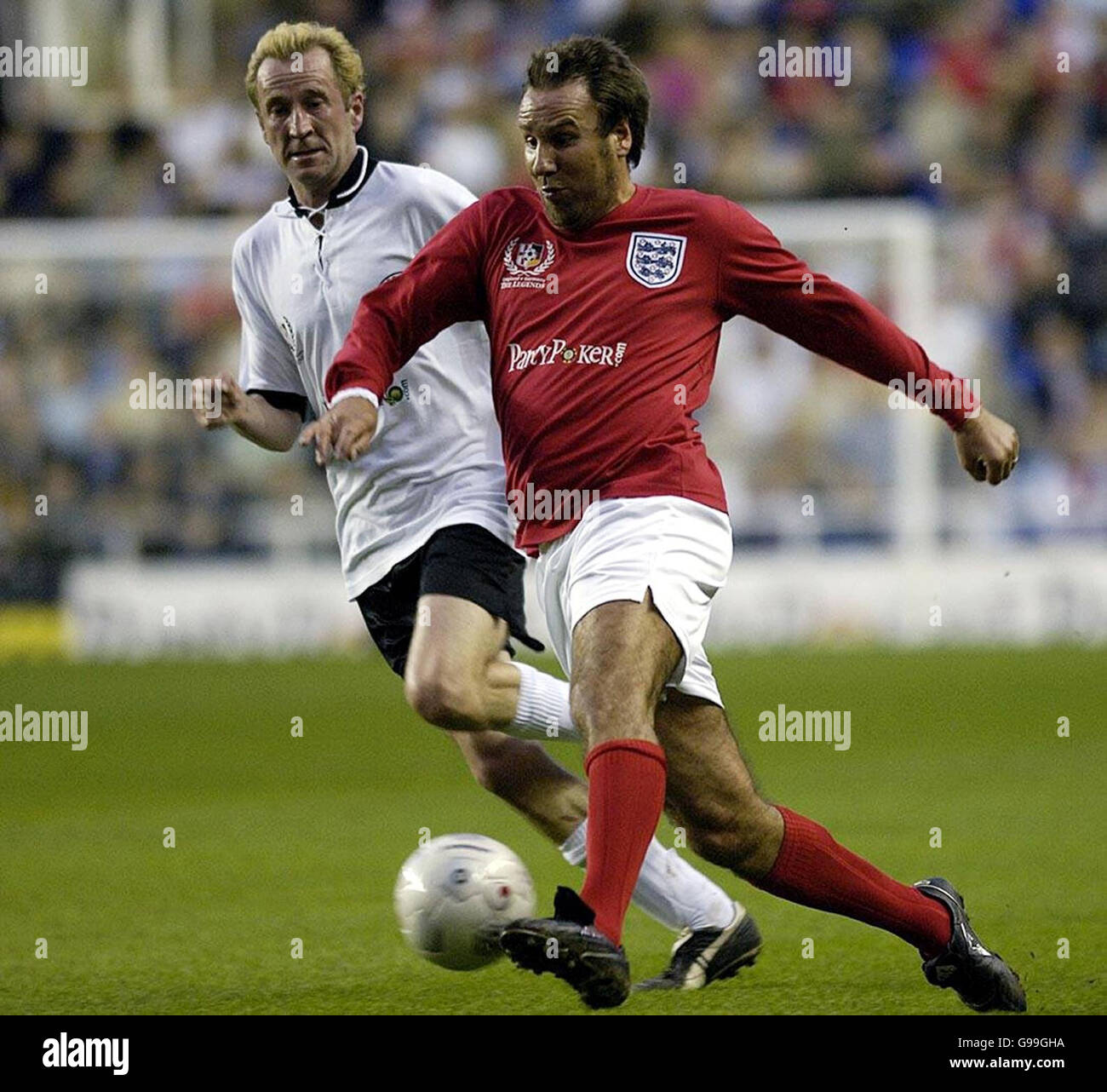 Der englische Paul Merson (R) im Einsatz gegen den deutschen Peter Lohmeyer während des Legends-Spiels im Madejski-Stadion in Reading. Stockfoto