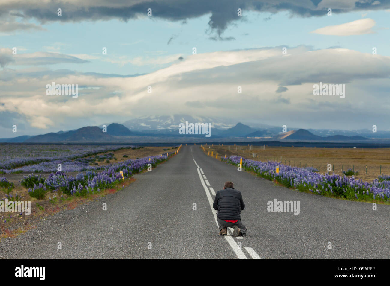 Die Straße führt durch weite isländische Landschaft. Stockfoto