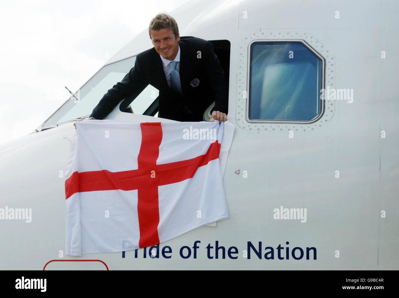 Englands Kapitän David Beckham schwingt eine Saint-George-Flagge aus dem Cockpit des Flugzeugs "Stolz der Nation" am Flughafen Luton. Stockfoto