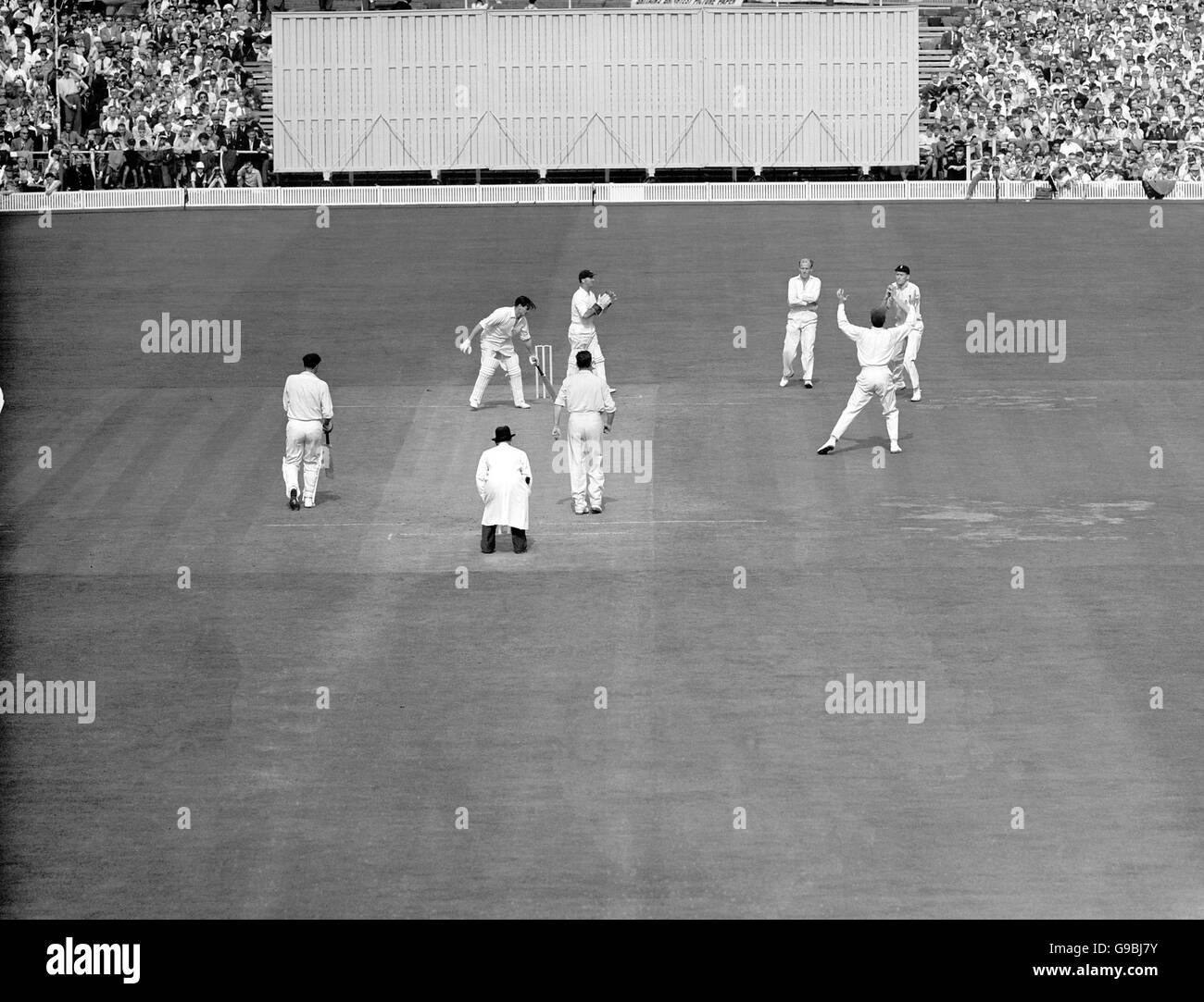 Cricket - The Ashes - Vierter Test - England gegen Australien - Old Trafford - Zweiter Tag. Der Engländer Alan Oakman (r) nimmt einen Haken, um den Australier Keith Miller (zweite l) für 6 aus der Bowlingbahn von Jim Laker (neben dem Schiedsrichter) zu entlassen. Stockfoto