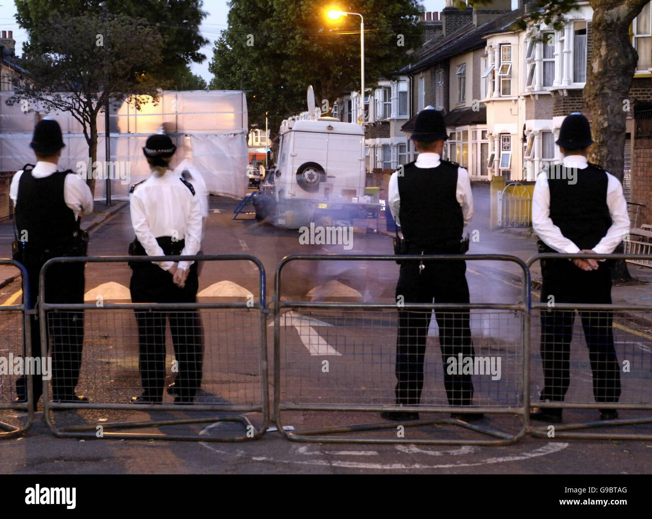 ANMERKUNG: AUFGENOMMEN MIT LANGSAMER BELICHTUNG die Polizei bewacht den Eingang zur Lansdown Road in Forest Gate, East London. Die beiden Brüder, die bei dem umstrittenen Anti-Terror-Angriff in der vergangenen Woche auf der Straße verhaftet wurden, wurden heute Abend ohne Anklage freigelassen. Stockfoto